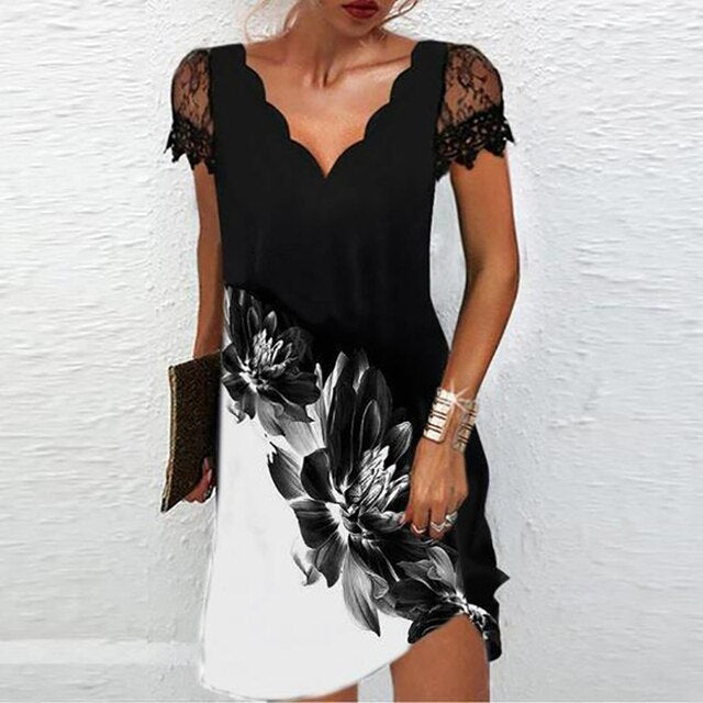 Frau in schwarzem Spitzenkleid mit Blumenmuster, V-Ausschnitt, Sommermode, elegant.