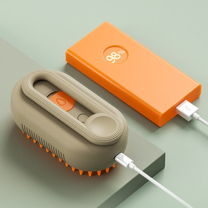 Beige Silikon-Kopfmassagegerät und orange Powerbank auf grünem Hintergrund, USB-Kabel angeschlossen.