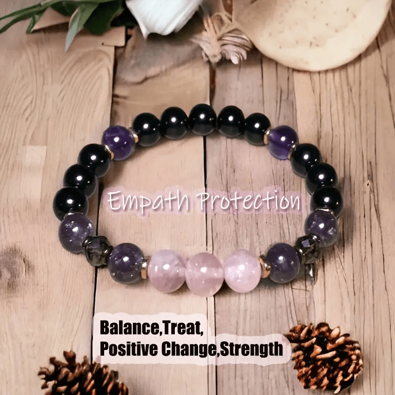 Schwarzes und lila Edelstein-Armband auf Holz, Empathie-Schutz, Balance, positive Veränderung.