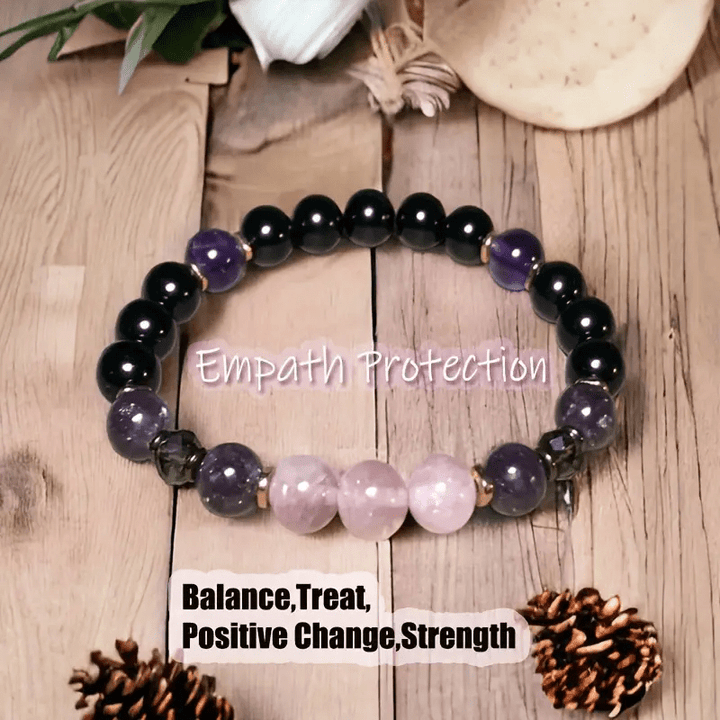 Schwarzes und lila Edelstein-Armband auf Holz, Empathie-Schutz, Balance, positive Veränderung.