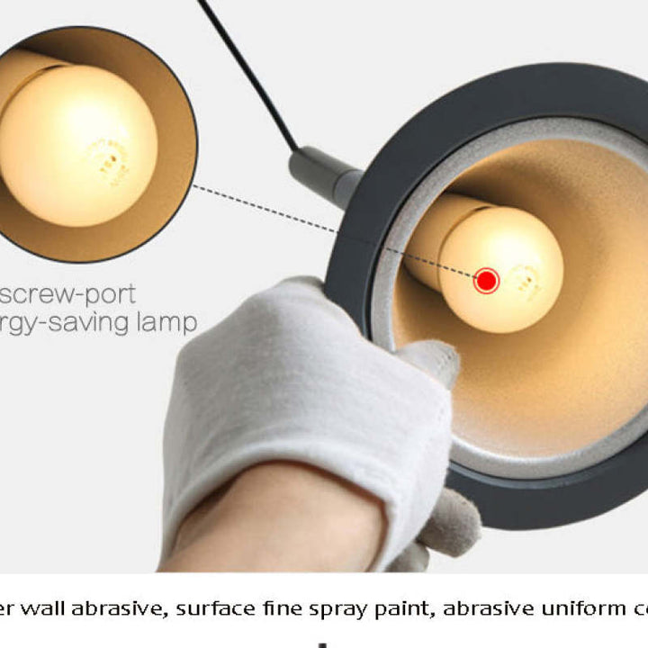 Glühbirne mit Schraubfassung, energiesparend, in grauer Lampe, Nahaufnahme, Hand mit Handschuh.
