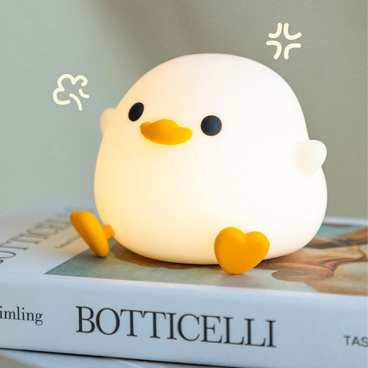 Niedliche Enten-Nachtlampe, LED, warmweiß, Kinderzimmer-Dekoration, auf Buch sitzend.