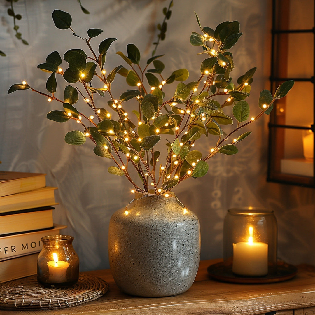 Eukalyptus-Zweige mit LED-Lichtern in grauer Vase, dekorative Beleuchtung, Wohnzimmer-Deko.