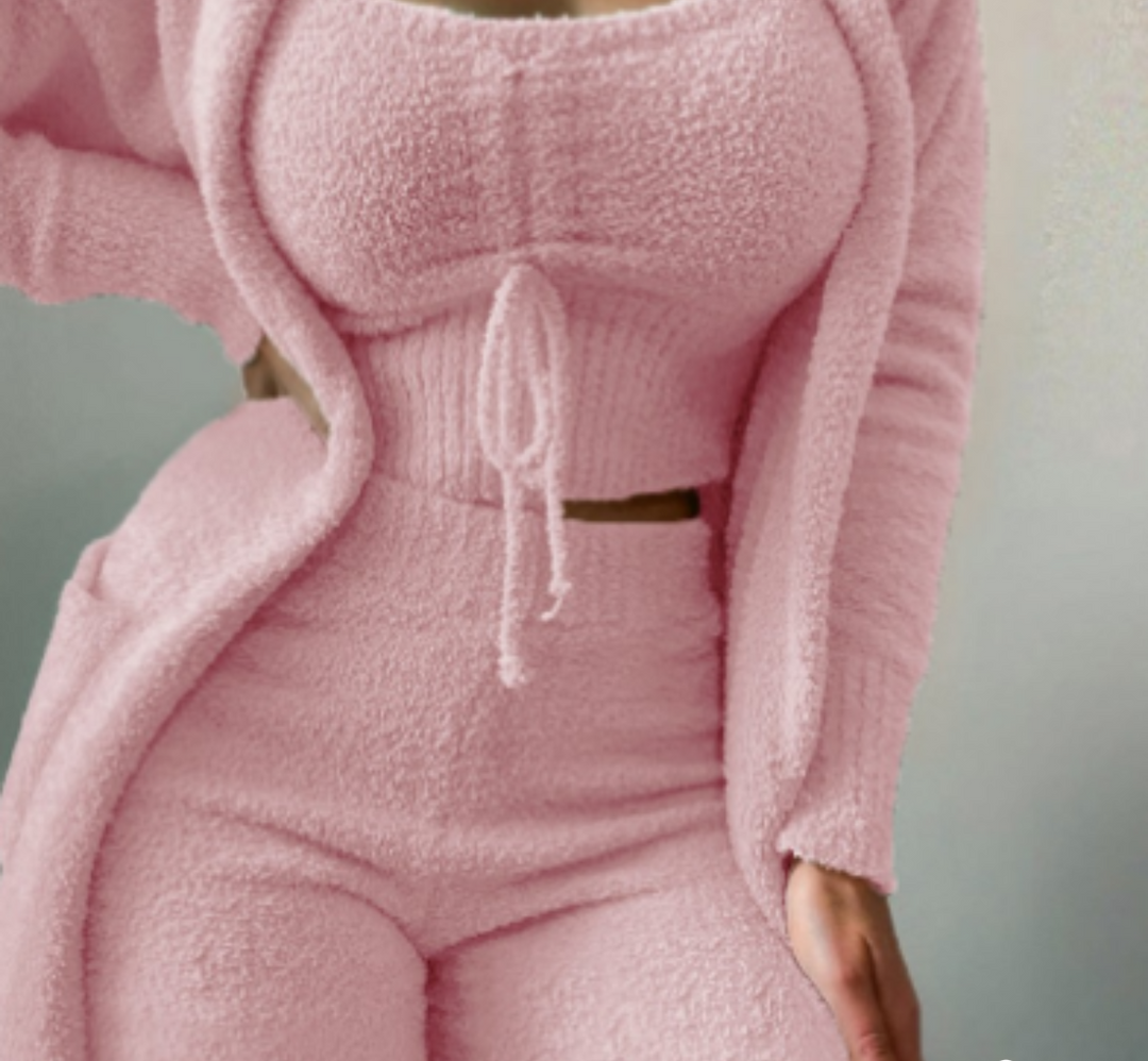 Frau in rosa Fleece-Loungewear-Set, bestehend aus Top, Hose und Cardigan.
