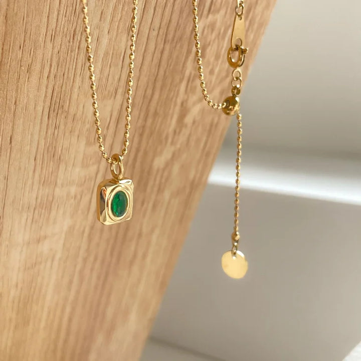 Goldene Halskette mit grünem Edelstein-Anhänger, elegantes Schmuckdesign, Damenaccessoire.