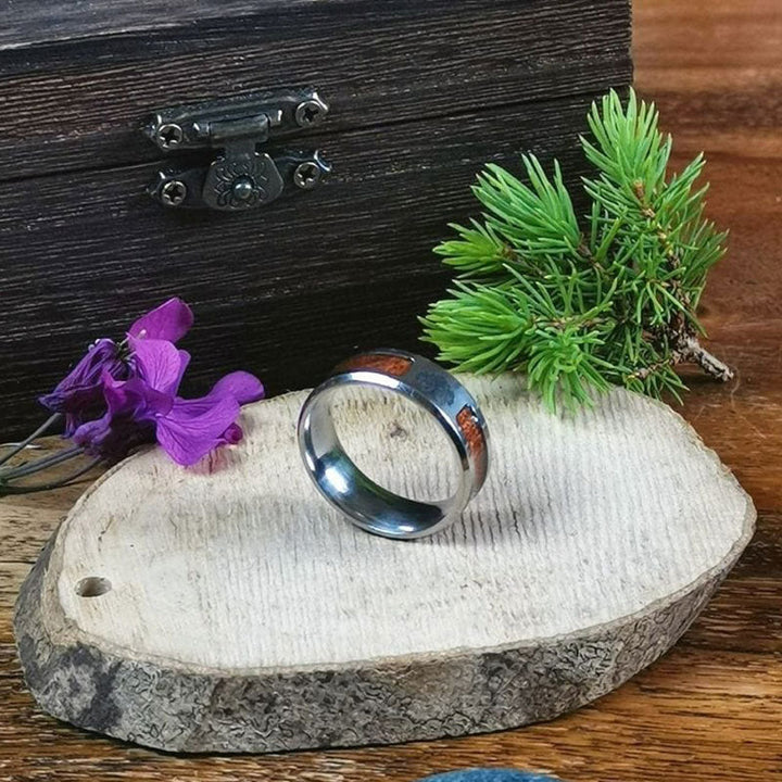 Silberner Herrenring mit Holzintarsien auf Holzscheibe, rustikaler Schmuck, Naturdeko.