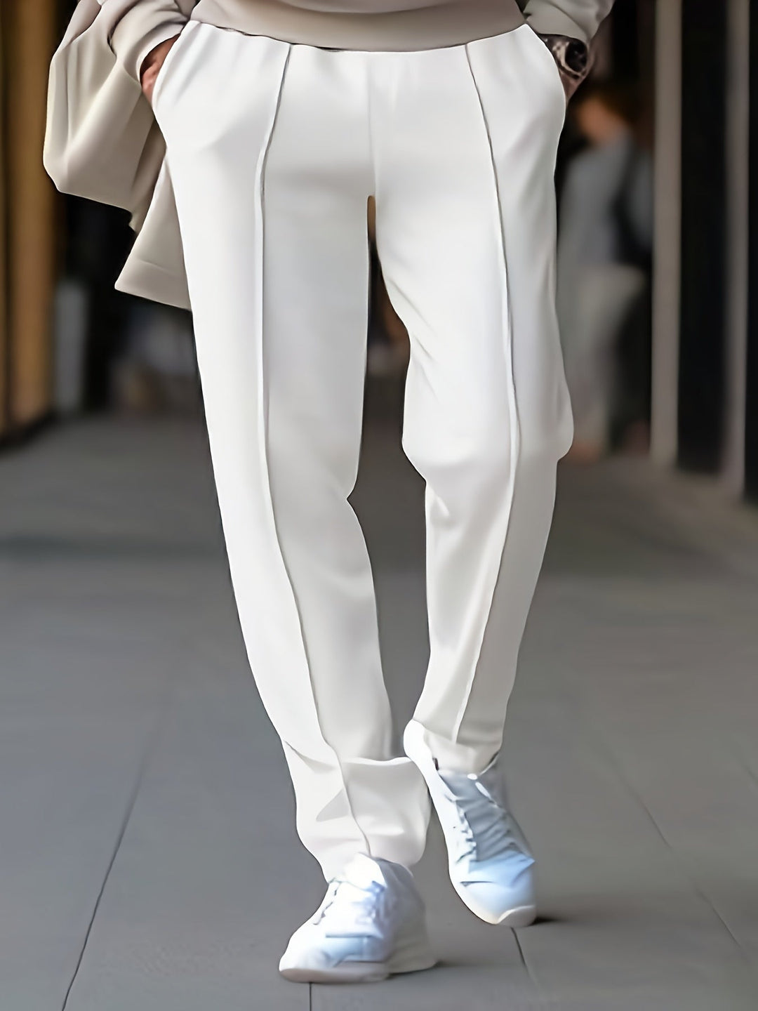 Weiße Damenhose mit Bügelfalten, elegant, aus Baumwolle, kombiniert mit weißen Sneakern.