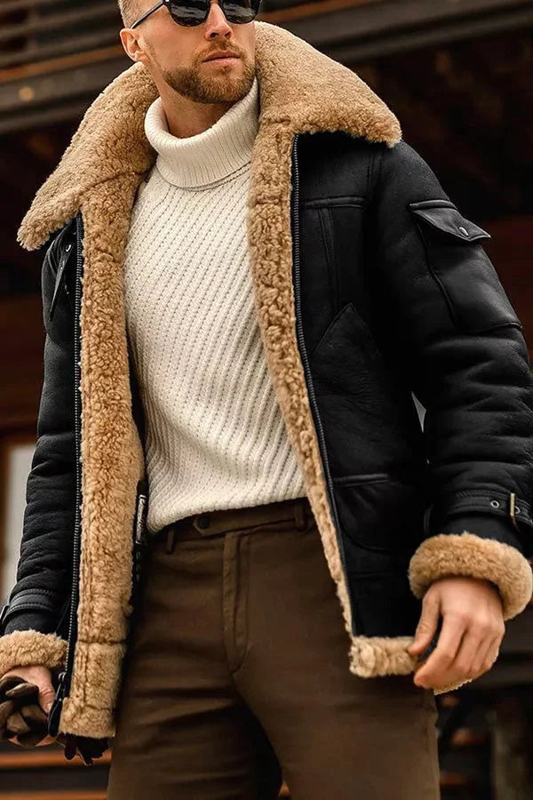 Mann in schwarzer Lederjacke mit beigem Lammfellfutter und weißem Rollkragenpullover.