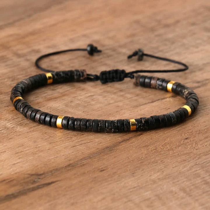 Armband aus Holz und Gold, verstellbar, handgefertigt, auf Holztisch, Schmuck für Männer.