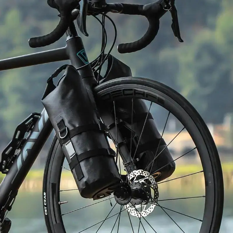 Wasserdichte schwarze Fahrradtaschen am Vorderrad, ideal für Outdoor-Abenteuer.