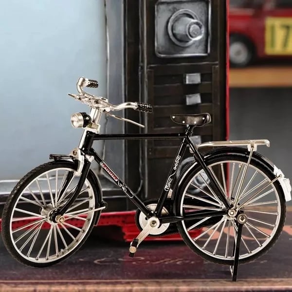 Schwarzes Miniatur-Fahrradmodell aus Metall vor Retro-Hintergrund, Sammlerstück, Dekoration.