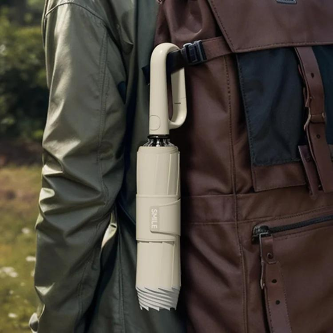 Beiger Regenschirm am Rucksack befestigt, Outdoor, kompakt, tragbar, wetterfest.