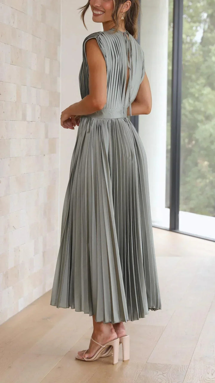 Frau in olivgrünem, plissiertem Maxikleid aus Chiffon, elegant, modern, Sommermode.