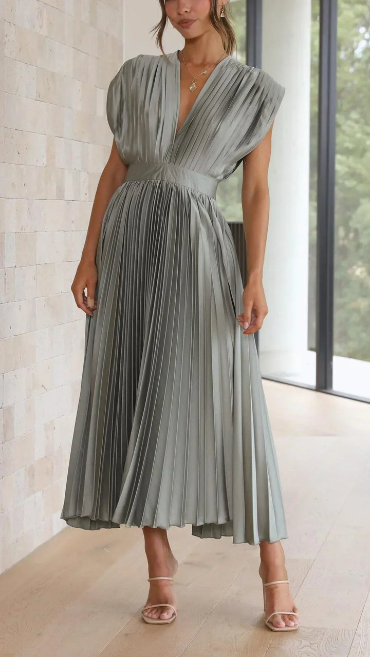Frau in olivgrünem, plissiertem Maxikleid, elegantes Design, ärmellos, V-Ausschnitt.