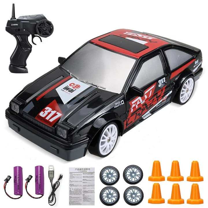 Ferngesteuertes Auto Set, schwarz-rot, mit Fernbedienung, Batterien, Rädern und Pylonen.