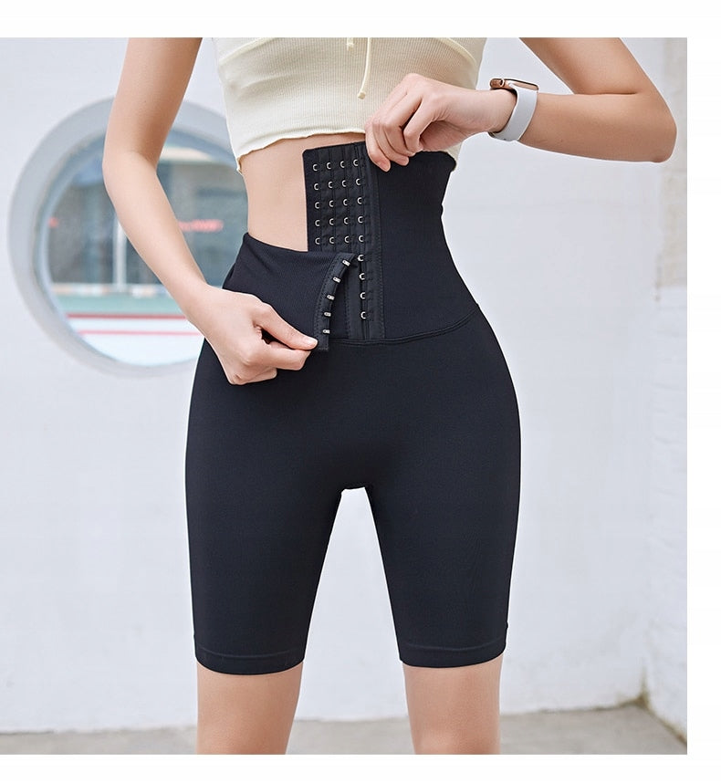Frau trägt schwarze Taillenformer-Shorts, hoher Bund, Shapewear, Fitnessmode.
