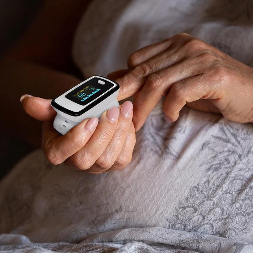 Ältere Person nutzt Finger-Pulsoximeter, Gesundheitsüberwachung, Sauerstoffsättigung messen.
