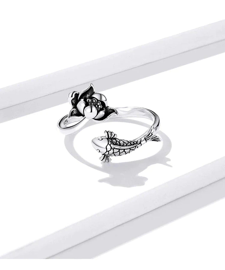 Silberner verstellbarer Ring mit Fisch- und Blumenmotiv, elegantes Schmuckdesign.