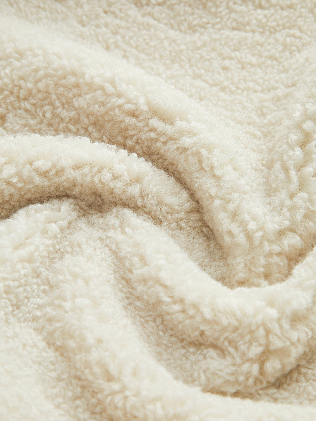 Weiche cremefarbene Fleece-Decke, kuscheliges Material, ideal für gemütliche Abende.