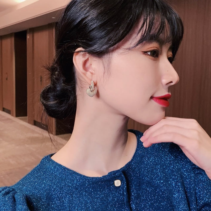 Frau mit blauen Kleid und silbernen Ohrringen, eleganter Look, seitliches Profil.