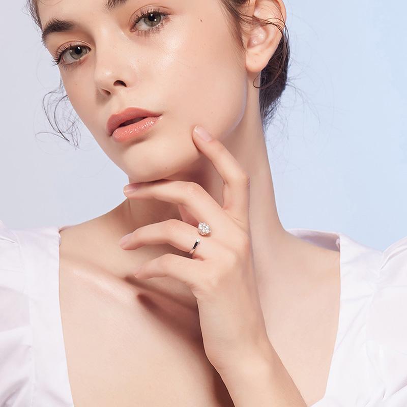 Frau mit elegantem Silberring, großer Kristall, weißes Kleid, Modefotografie, Nahaufnahme.