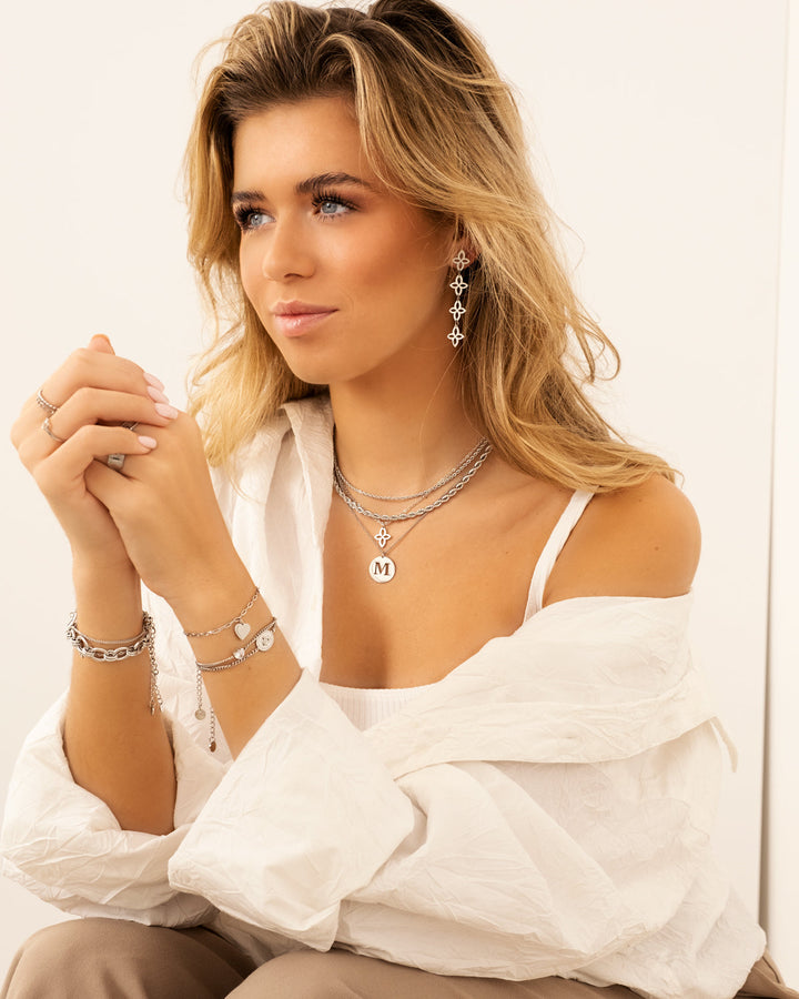Frau mit silbernen Schmuck, Halsketten, Ohrringe, Armbänder, weißes Hemd, modisches Accessoire.