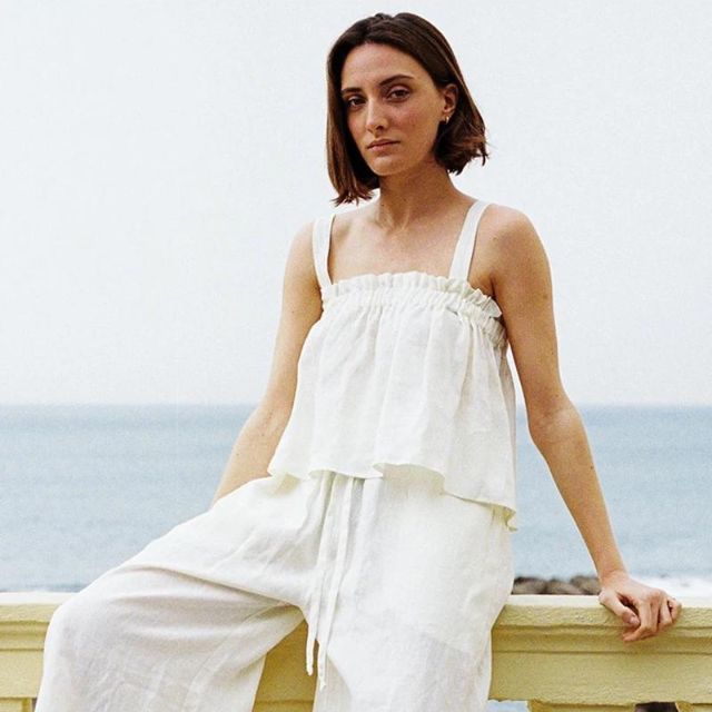 Frau in weißem Leinen-Sommerkleid am Meer, entspannte Mode, Strandkleidung, Damenbekleidung.