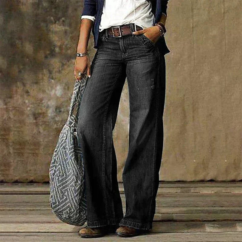 Frau in grauer, weiter Jeans mit niedriger Taille, Retro-Stil, Straße, Mode, breite Beine.