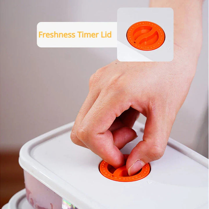 Hand dreht orangefarbenen Frische-Timer-Deckel auf weißem Vorratsbehälter.