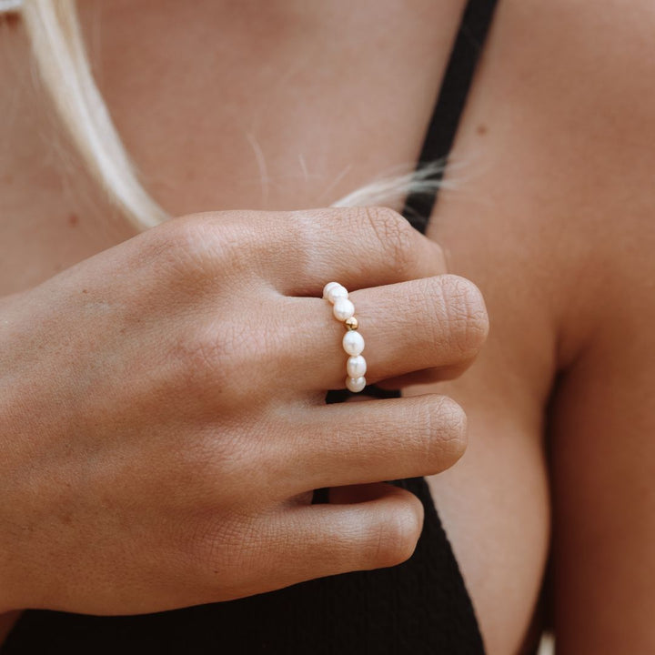 Frau trägt Süßwasser-Perlenring, eleganter Schmuck, weiß, modisch, Hand, Nahaufnahme.