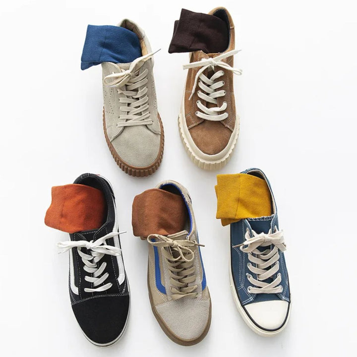 Fünf Paar bunte Sneakers mit Socken, verschiedene Farben, modische Freizeitschuhe.