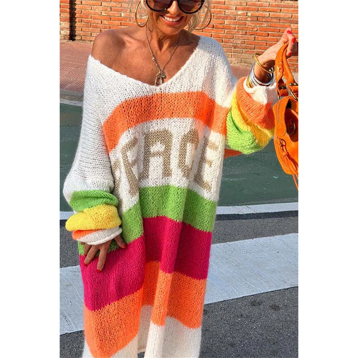 Frau trägt bunten Strickcardigan mit Regenbogenstreifen und "PEACE"-Schriftzug, modisch, lässig.
