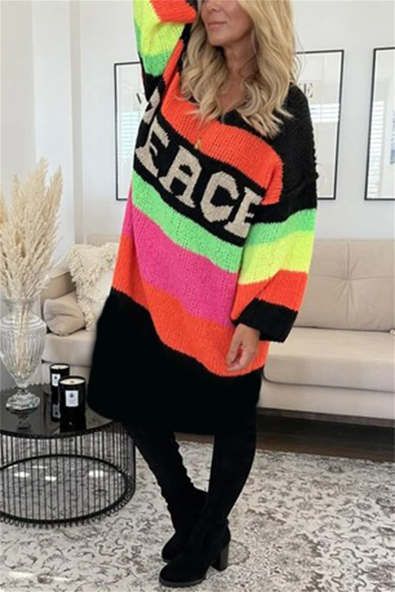 Frau trägt bunten Strickcardigan mit "Peace"-Schriftzug, Regenbogenfarben, gemütlich, modisch.