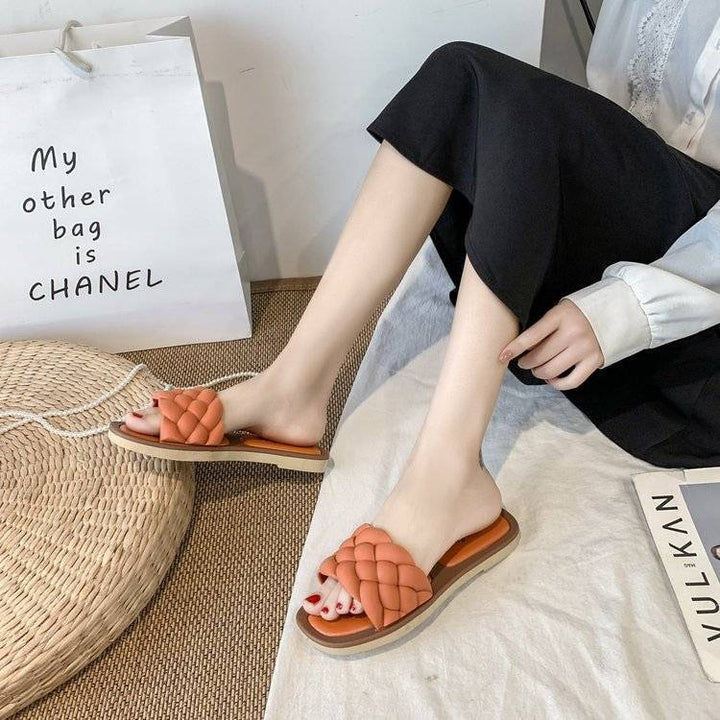 Frau trägt orange geflochtene Sandalen, Sommermode, bequeme Damen-Slipper, Freizeitkleidung.