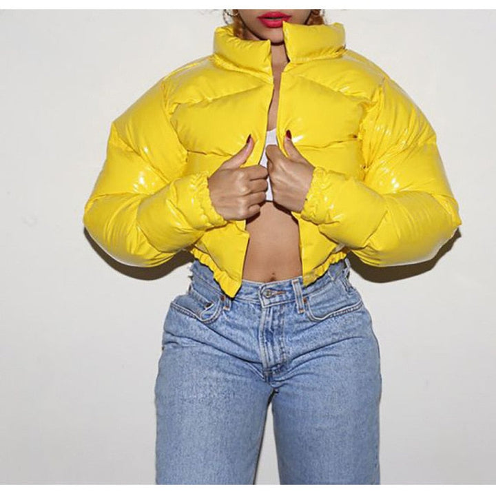 Frau in gelber Daunenjacke, blaue Jeans, modische Winterkleidung, leuchtende Farben.