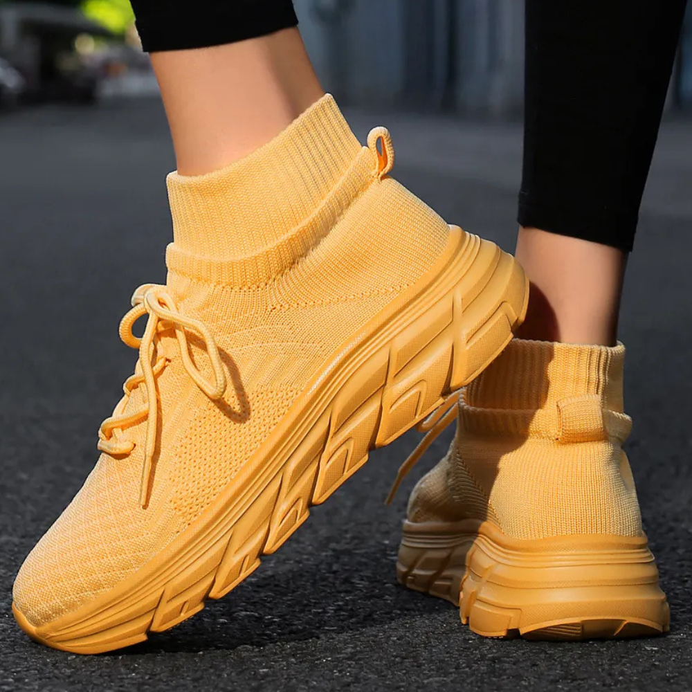 Gelbe Sneaker aus Strickmaterial, atmungsaktiv, mit dicker Sohle, ideal für Freizeit und Sport.