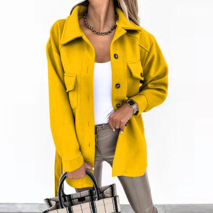 Frau in gelber Wolljacke, weiße Bluse, beige Hose, kariertes Handtasche, modisch, elegant.