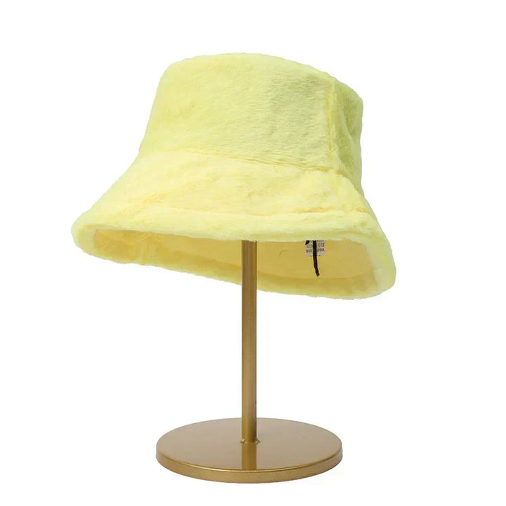 Gelber Plüsch-Bucket-Hut auf goldenem Ständer, modisches Accessoire, Damenmode.
