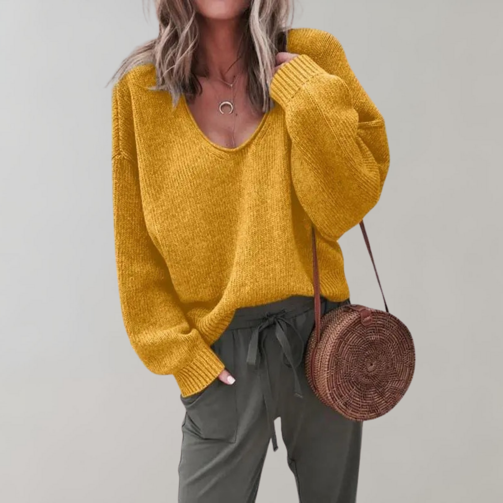 Frau in gelbem Strickpullover, olivgrüner Hose, runder Strohtasche, modisch, lässig.