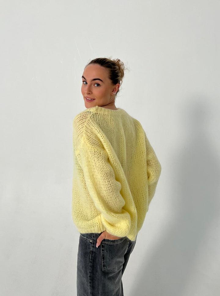 Frau in gelbem Strickpullover, lässig, modisch, Herbstmode, Damenbekleidung, Rückansicht.