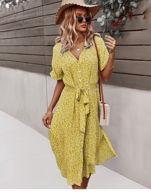 Frau in gelbem Sommerkleid mit Strohhut und Sonnenbrille, modisch, lässig, draußen.