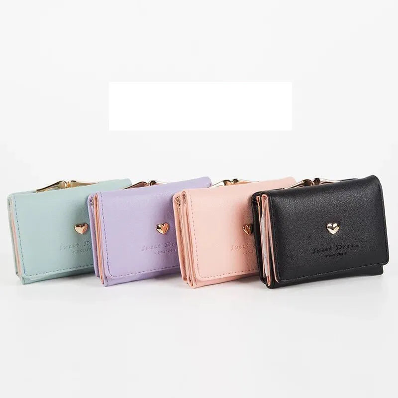 Vier bunte Damen-Geldbörsen aus Leder mit Herz-Design, Pastellfarben, kompakt, elegant.