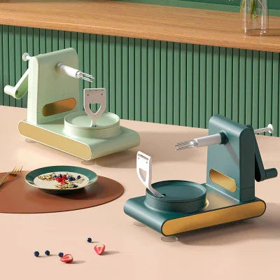 Grüner und mintfarbener manuelle Nudelmaschine aus Kunststoff auf Küchentisch.