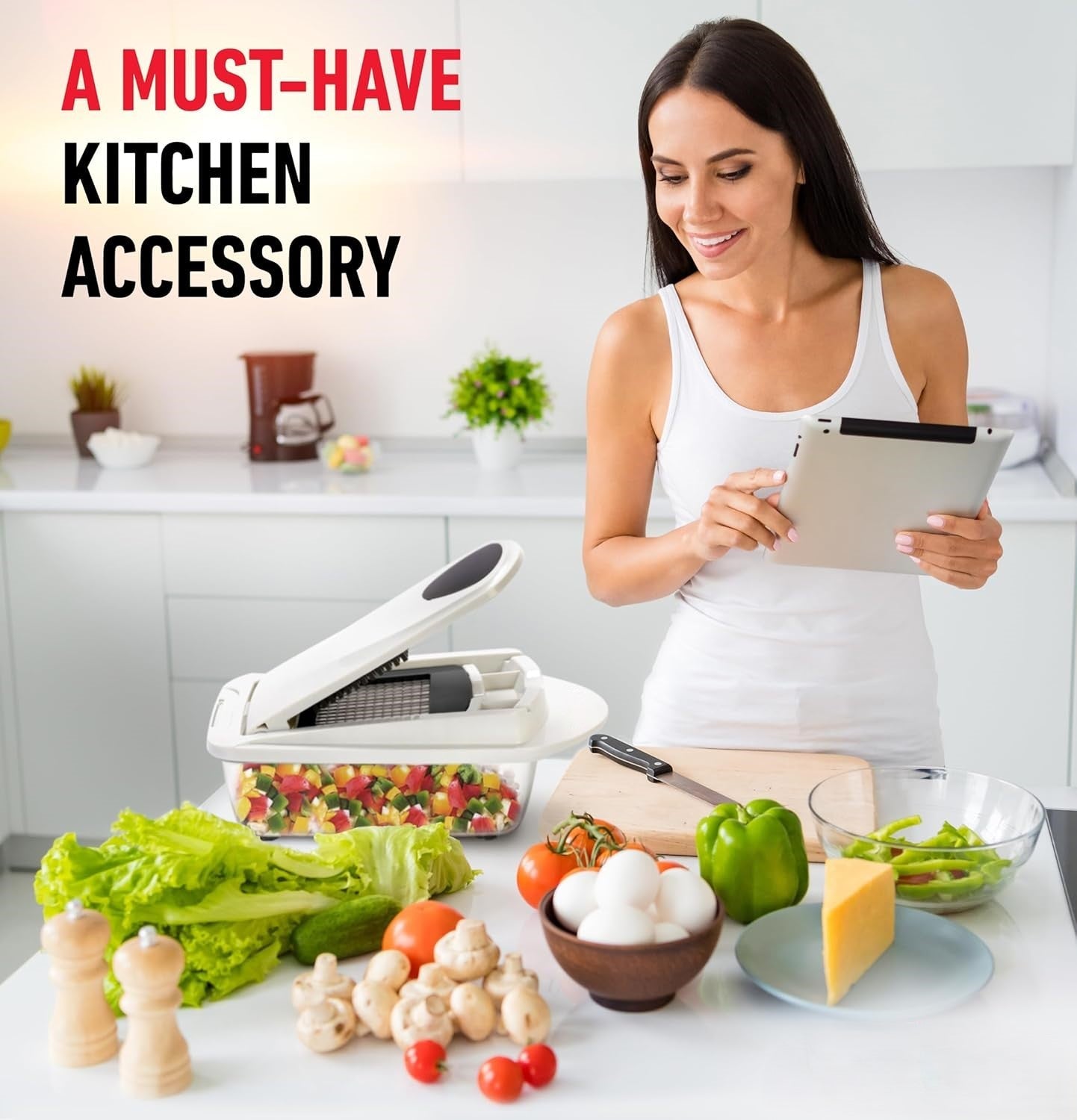 Frau in moderner Küche mit Gemüseschneider, frischem Gemüse und Tablet, Küchenzubehör.