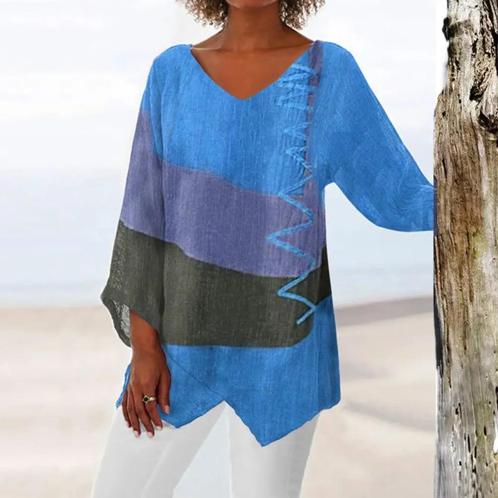 Frau in blauer geometrischer Print-Bluse mit V-Ausschnitt und langen Ärmeln, lässiger Herbststil.