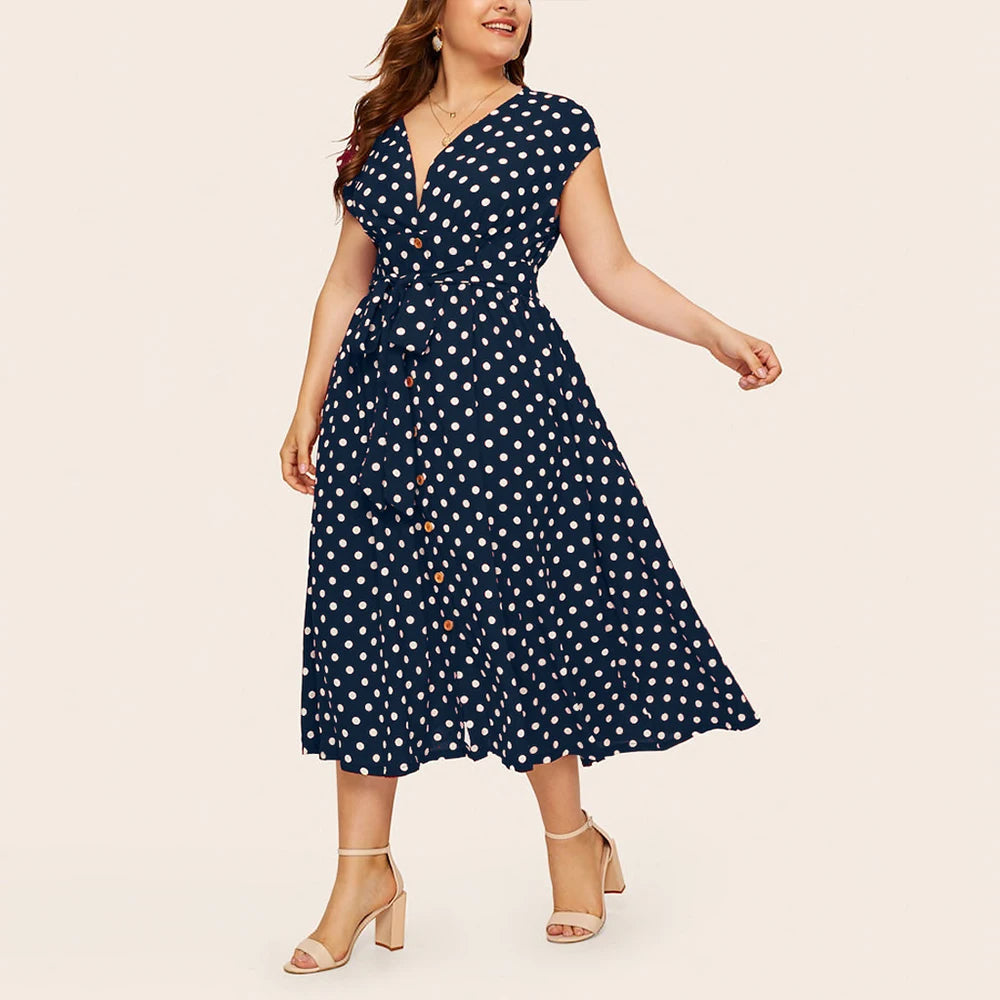 Frau in blauem gepunktetem Kleid, knielang, mit V-Ausschnitt, Sommermode, elegant.