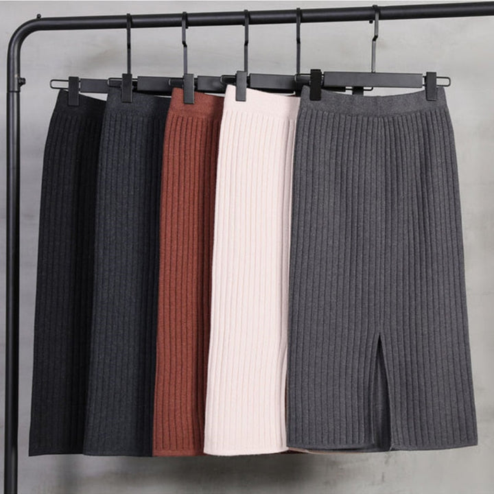 Fünf gerippte Strickröcke in verschiedenen Farben auf Kleiderbügeln, modisch und elegant.