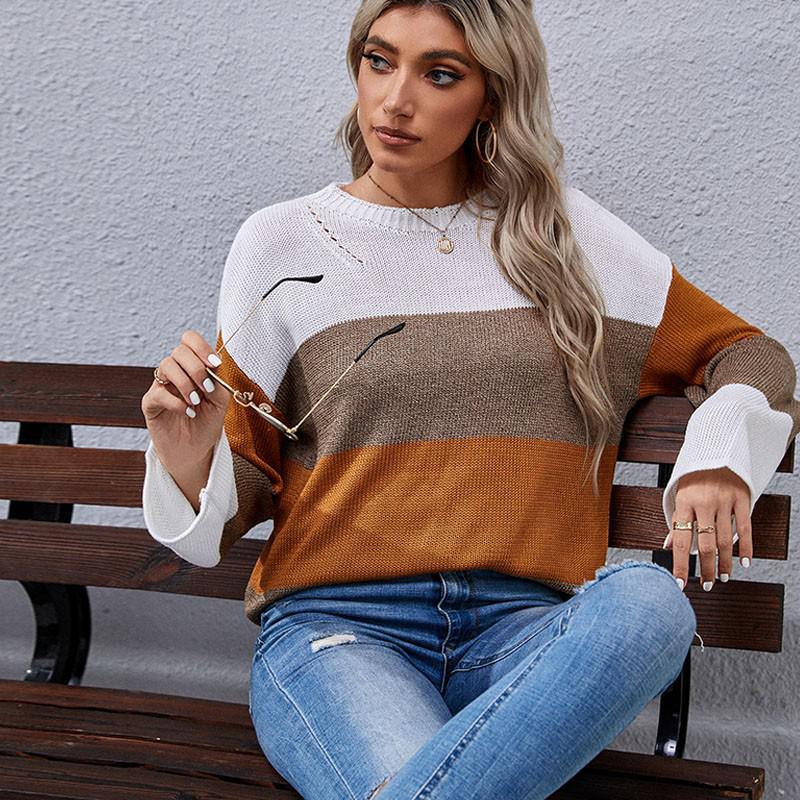 Frau in gestreiftem Pullover, Herbstfarben, sitzt auf Bank, modische Sonnenbrille, lässiger Look.