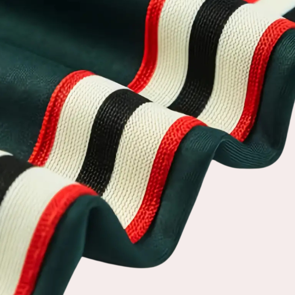 Grüner Stoff mit roten, schwarzen und weißen Streifen, Textilmaterial, Modeaccessoire.