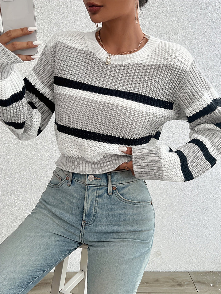 Frau in gestreiftem Strickpullover, weiß-schwarz, mit blauen Jeans, modisch, lässig.